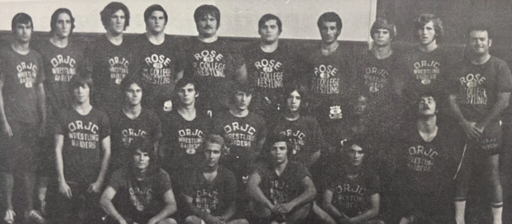 Black and white group photo of a men's wrestling team wearing matching shirts that read 'Rose State College Wrestling.' The team is arranged in several rows, with coaches and athletes posing together indoors against a plain background.